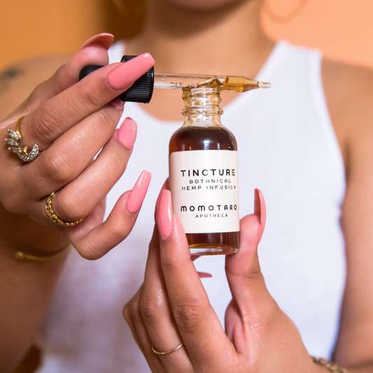 Shop Tincture - Torso with White Tanktop Holding a Bottle of Tincture
