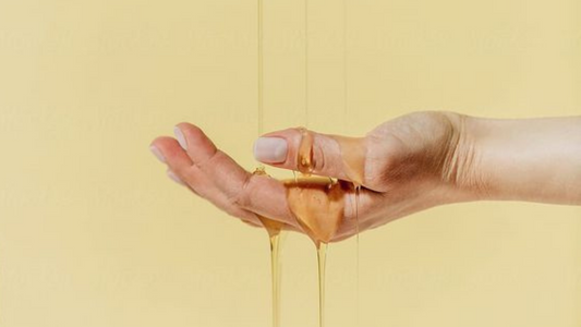 The Definitive Guide to Using Lube - Hand with Lube on Yellow Background