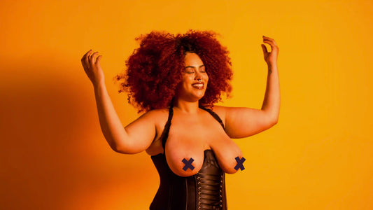 How to be a Domme for beginners. Beautiful black woman with afro smiles on golden background in black bustier. 