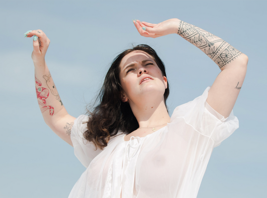How to Not Panic & Fake News - Model in White Flowy Blouse with Hands in the Air