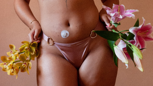 Closeup of model wearing pink, silk thing and holding colorful flowers