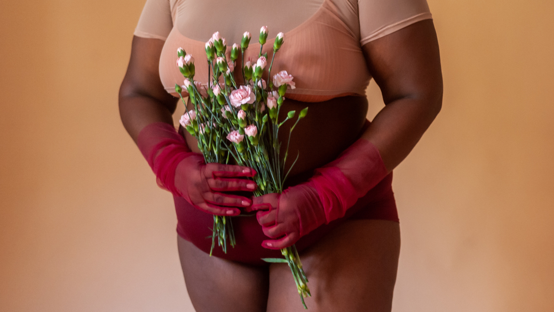 What to Expect During Pregnancy & Postpartum - Closeup of model in red gloves holding white flowers