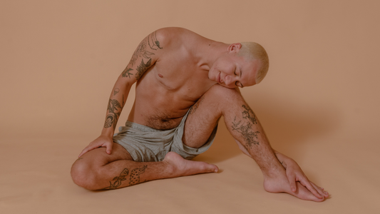 ABCs of LGBTQIA - Clark posing on the floor in blue shorts