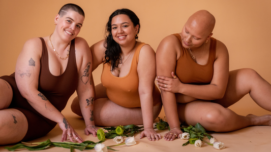 Pandemic Bodies Meet Pride Diets - Three models happily posing on the ground with white roses