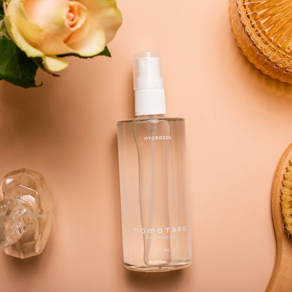 Hydrosol on pink background with flowers and bathroom items