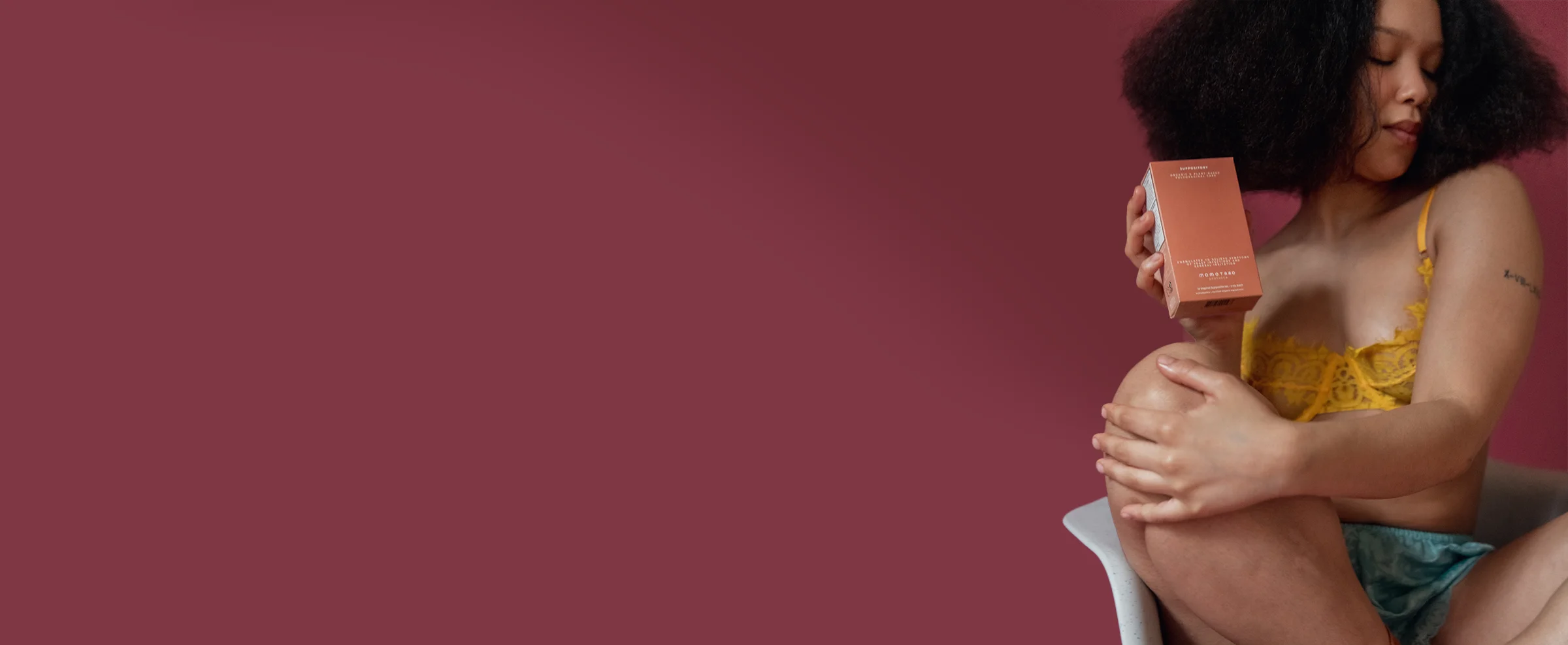 Woman holding a suppository against a red background