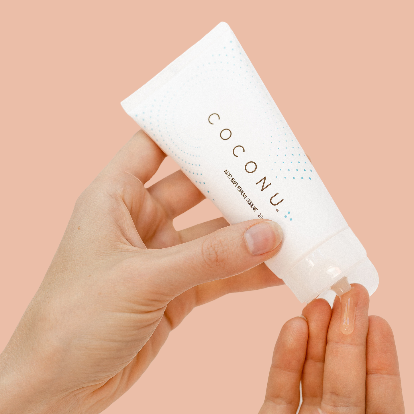 Coconu lubricant bottle squeezing on hand