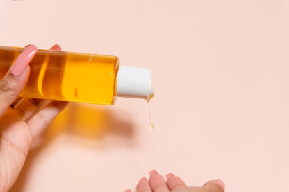 pouring out body oil into hands