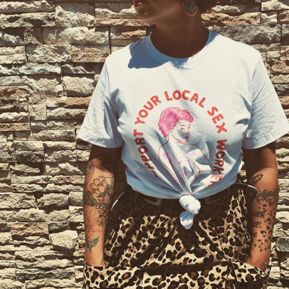 person wearing sylsw tee shirt with dress and rock wall in background