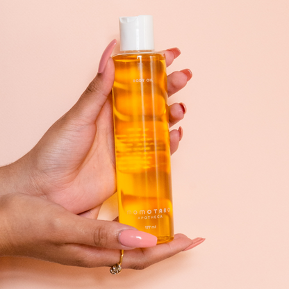 hands holding the certified organic bodyoil centered